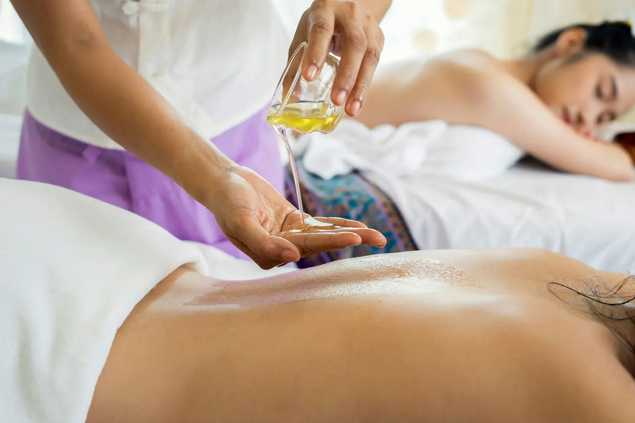 Terapeuta aplicando aceite esencial durante masaje relajante