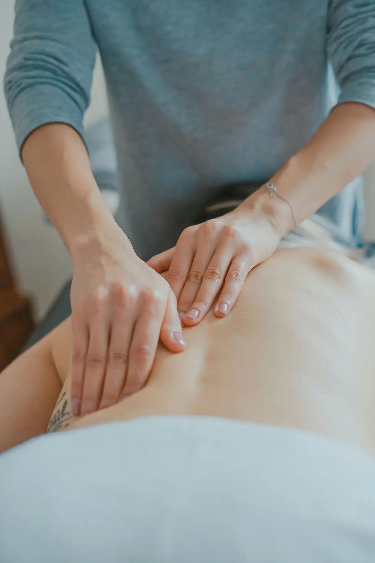 Terapeuta realizando masaje en zona lumbar, reflexología